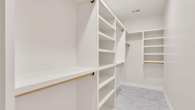 spacious closet with marble finish floor and visible vents