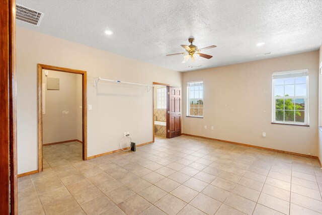 unfurnished bedroom with ceiling fan, a textured ceiling, and light tile patterned floors