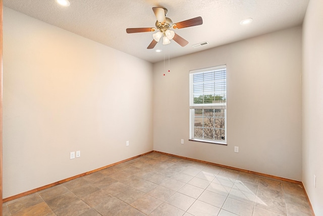 unfurnished room with ceiling fan and a textured ceiling