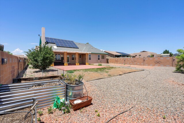 back of house with a patio and solar panels