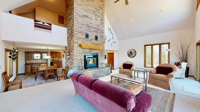 living room with light colored carpet, ceiling fan, high vaulted ceiling, and a brick fireplace