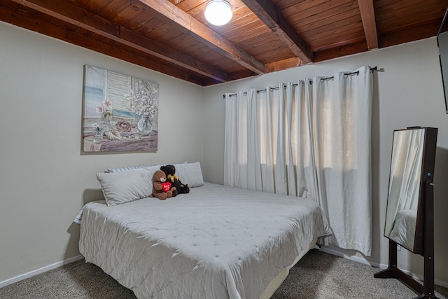 bedroom with beam ceiling, carpet floors, and wooden ceiling