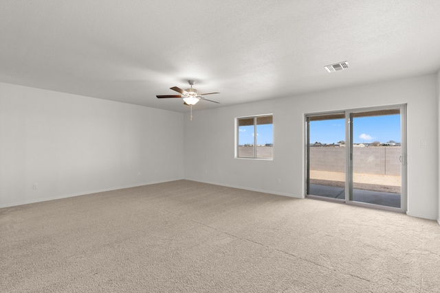 carpeted spare room featuring ceiling fan and a textured ceiling