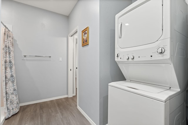 laundry area featuring light hardwood / wood-style flooring and stacked washer and dryer