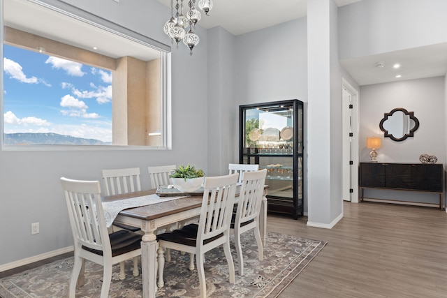 dining space with hardwood / wood-style flooring and an inviting chandelier