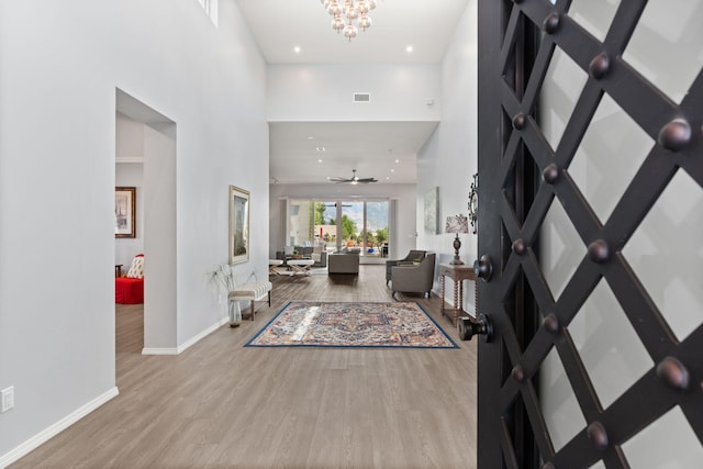 entryway with light hardwood / wood-style flooring, a high ceiling, and ceiling fan