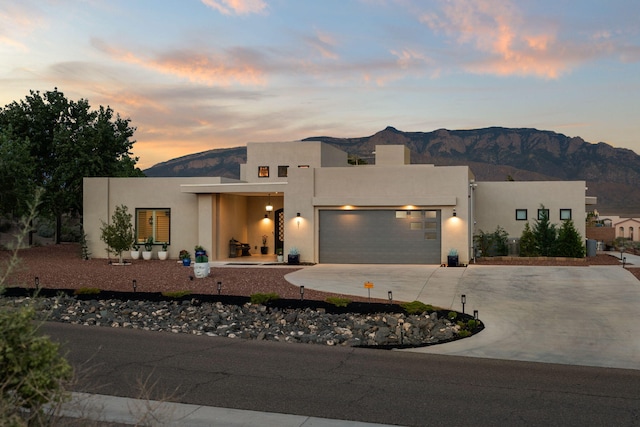 pueblo-style house featuring a mountain view and a garage