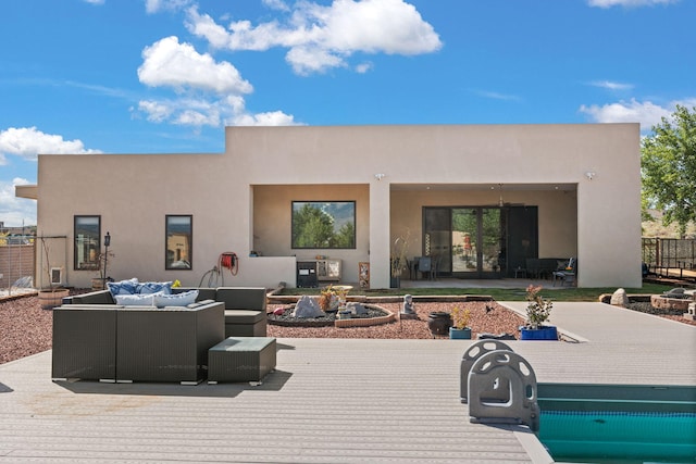 back of house with an outdoor living space with a fire pit and a patio area