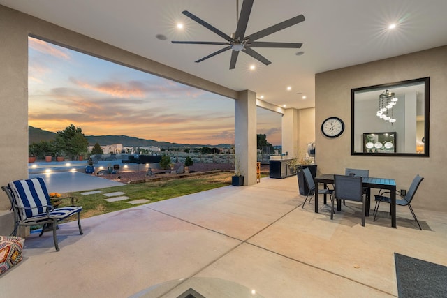 patio terrace at dusk featuring ceiling fan