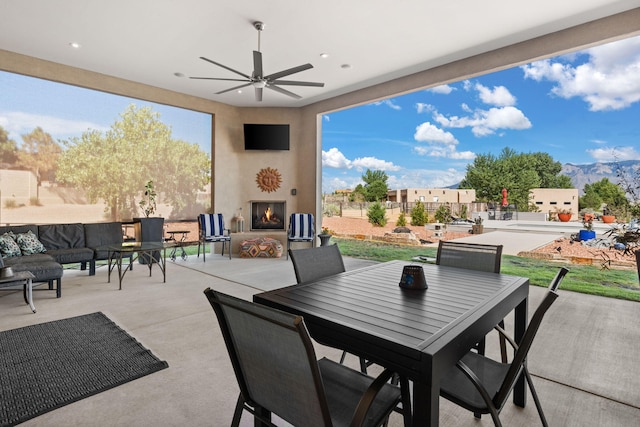 view of patio featuring an outdoor living space with a fireplace and ceiling fan