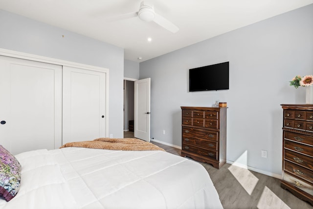 bedroom featuring light wood-type flooring, ceiling fan, and a closet