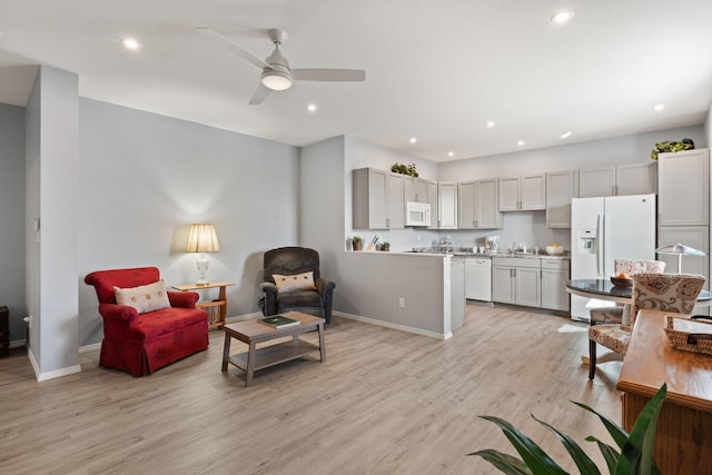 living room with ceiling fan, sink, and light hardwood / wood-style flooring