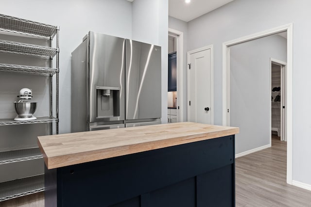 kitchen featuring stainless steel refrigerator with ice dispenser, hardwood / wood-style flooring, and wood counters