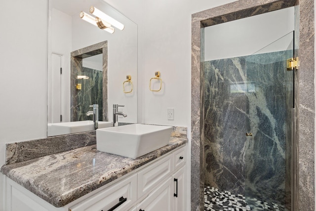 full bath with a marble finish shower and vanity