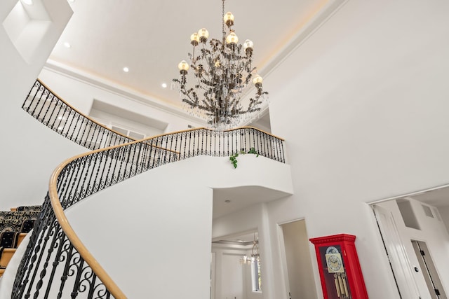 stairs featuring a towering ceiling and a notable chandelier