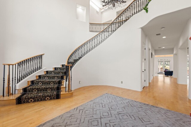 stairway with a high ceiling and a notable chandelier