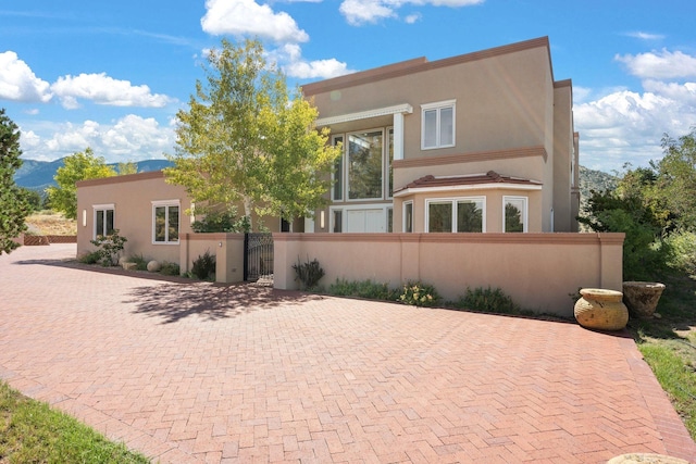 view of front of house featuring a fenced front yard, a gate, and stucco siding