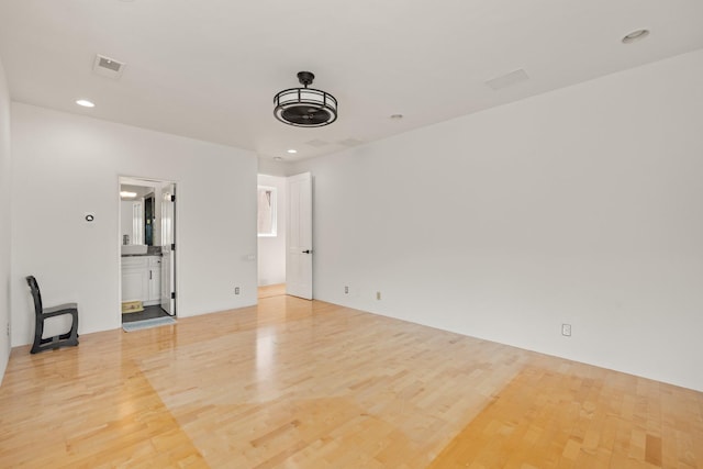 spare room with recessed lighting, visible vents, and wood finished floors