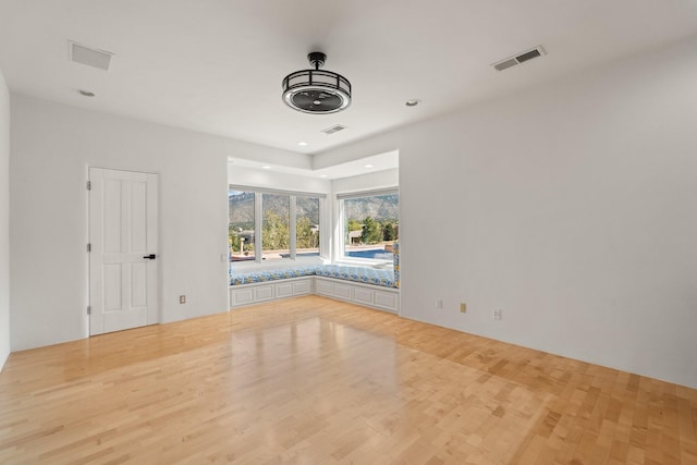 spare room featuring wood finished floors, visible vents, and recessed lighting