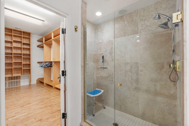 bathroom featuring visible vents, a shower stall, and wood finished floors