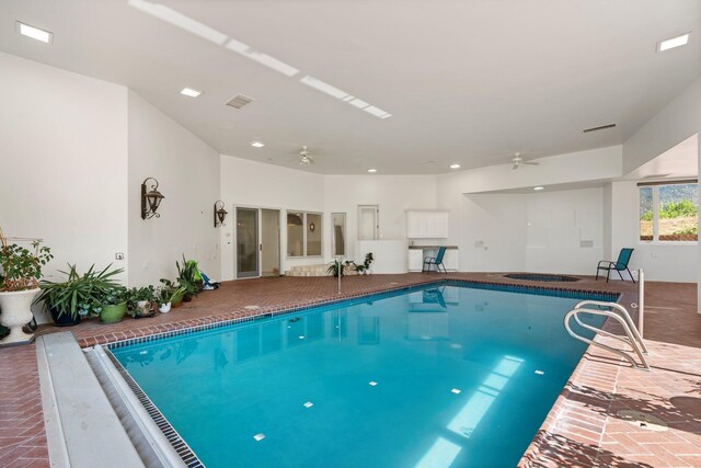 view of swimming pool with ceiling fan and an indoor hot tub