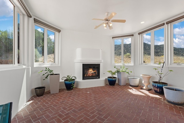 sunroom / solarium featuring a glass covered fireplace and a healthy amount of sunlight