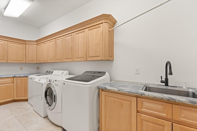 laundry room featuring independent washer and dryer, cabinet space, a sink, and light tile patterned floors