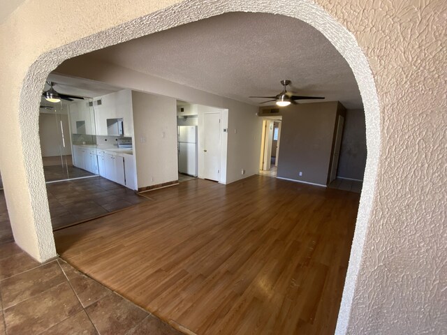 spare room with dark tile patterned floors, a textured ceiling, and ceiling fan