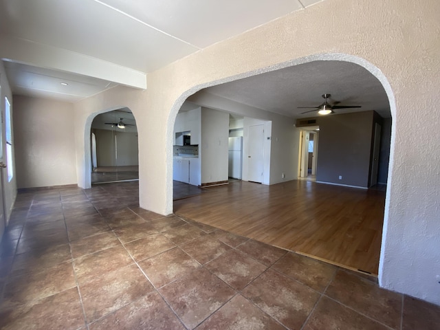 tiled empty room featuring a textured ceiling and ceiling fan