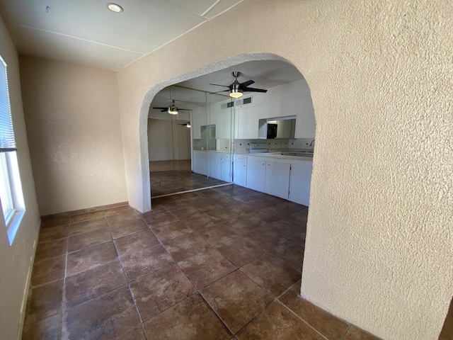 kitchen featuring white cabinets, ceiling fan, and sink