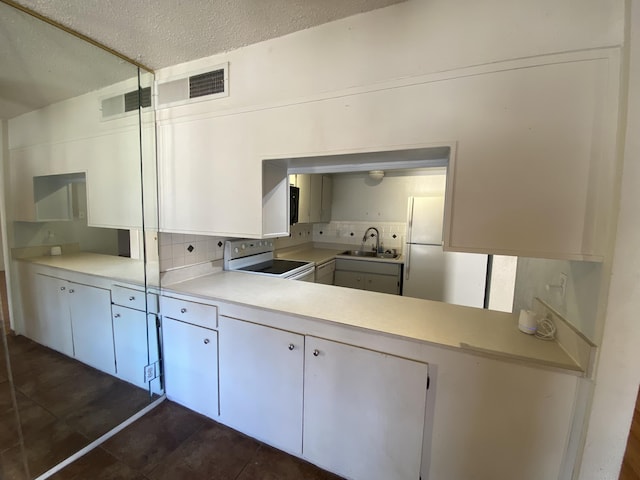 kitchen with sink, electric range, and white cabinets