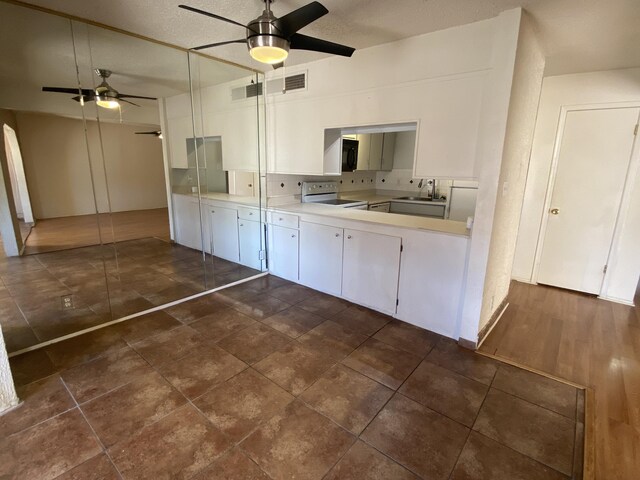 kitchen with sink, white appliances, a textured ceiling, white cabinets, and decorative backsplash