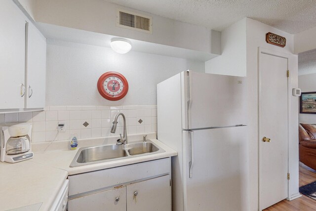 kitchen with sink, white appliances, light tile patterned flooring, and backsplash