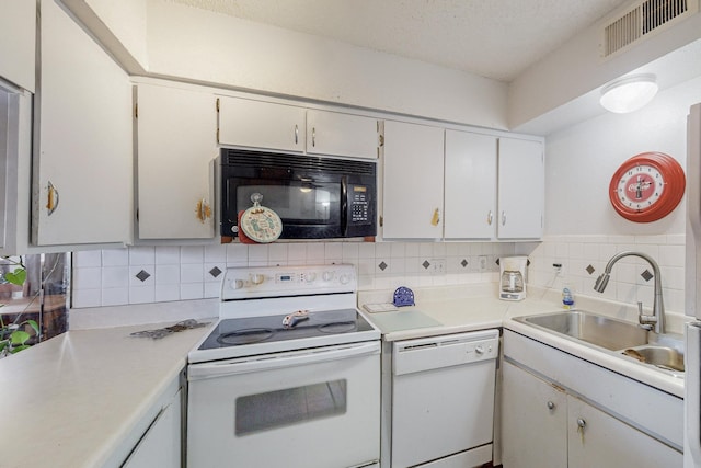 kitchen with white appliances, sink, white cabinets, and decorative backsplash