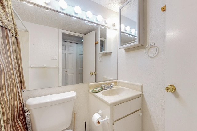 bathroom with vanity, a textured ceiling, and toilet