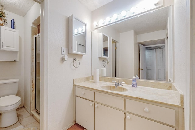 bathroom with a textured ceiling, toilet, vanity, and a shower with door