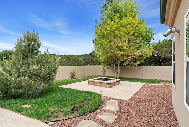 view of yard with an outdoor fire pit and a patio