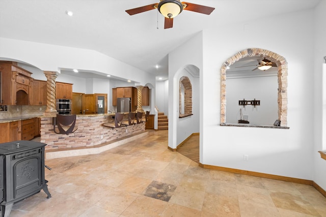 interior space featuring ceiling fan, backsplash, and stainless steel refrigerator