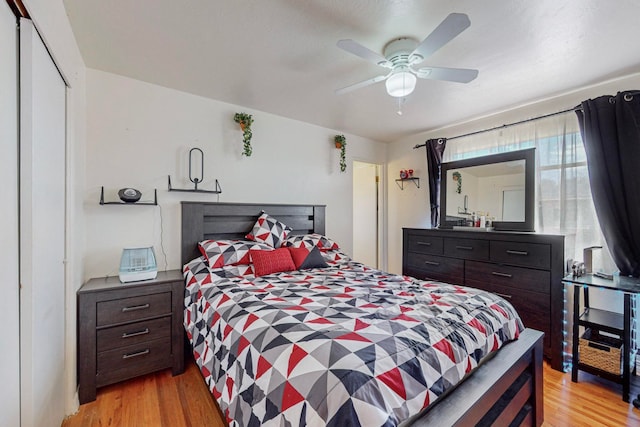 bedroom with light hardwood / wood-style flooring, ceiling fan, and a closet