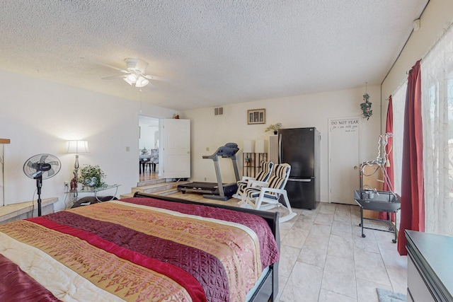 bedroom featuring stainless steel fridge, a textured ceiling, and ceiling fan