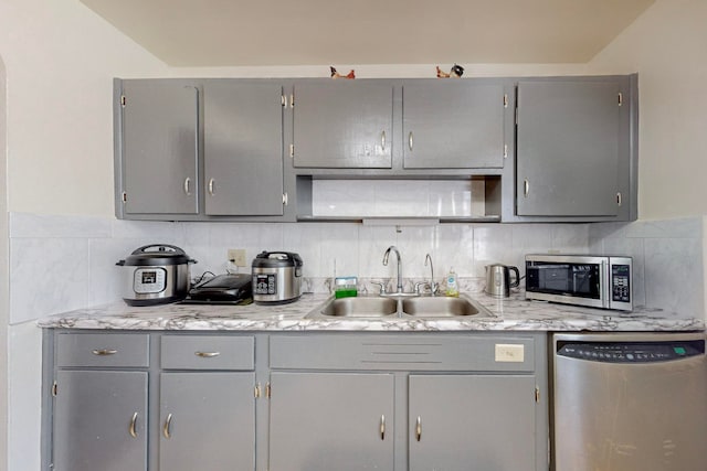 kitchen with gray cabinetry, sink, appliances with stainless steel finishes, and decorative backsplash