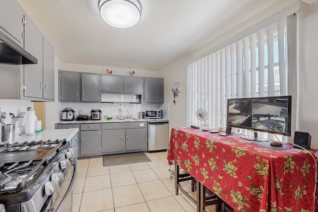 kitchen with backsplash, stainless steel appliances, sink, gray cabinetry, and light tile patterned flooring