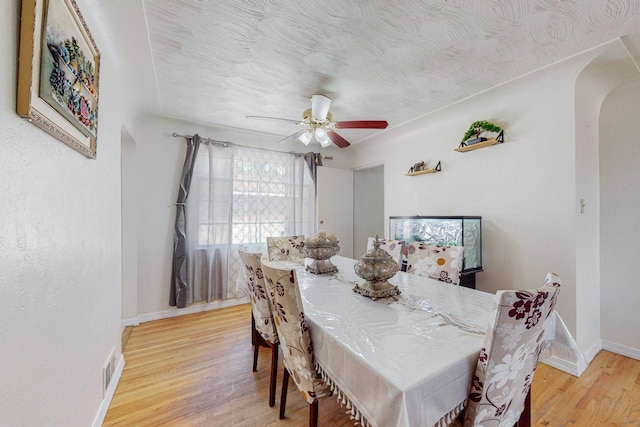 dining space with a textured ceiling, light hardwood / wood-style flooring, and ceiling fan