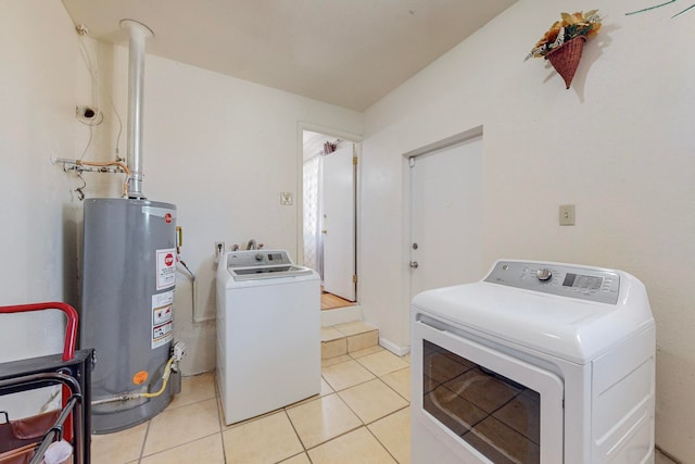 clothes washing area featuring light tile patterned flooring, independent washer and dryer, and water heater