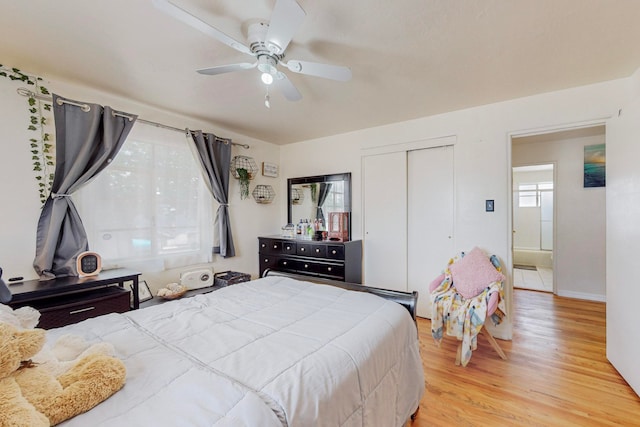 bedroom with light wood-type flooring, ceiling fan, and a closet