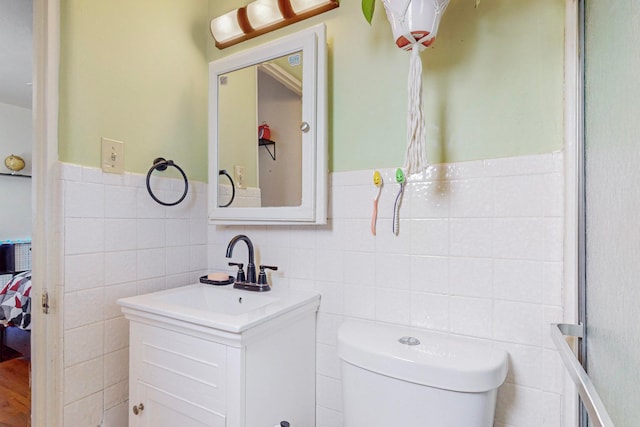 bathroom featuring tile walls, toilet, vanity, and tasteful backsplash