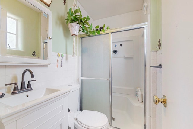 bathroom featuring vanity, toilet, walk in shower, and decorative backsplash