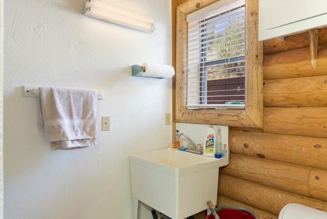 bathroom with log walls and sink