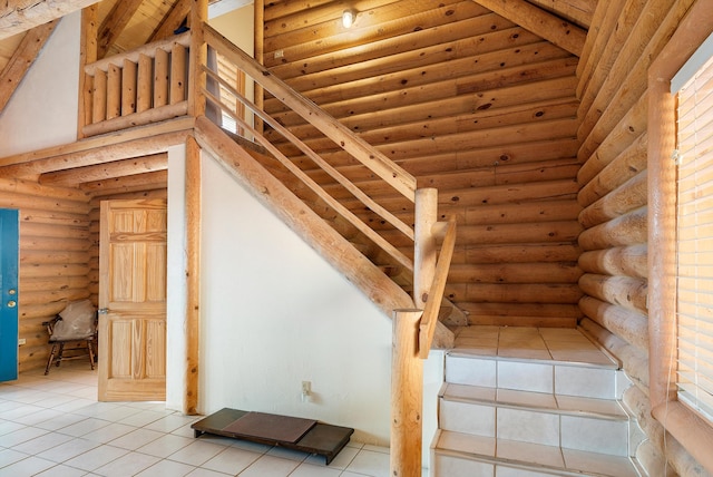 stairs featuring high vaulted ceiling, rustic walls, tile patterned floors, and beam ceiling