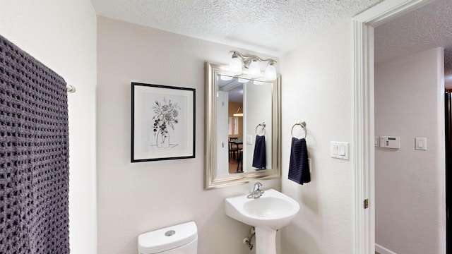 bathroom featuring toilet and a textured ceiling